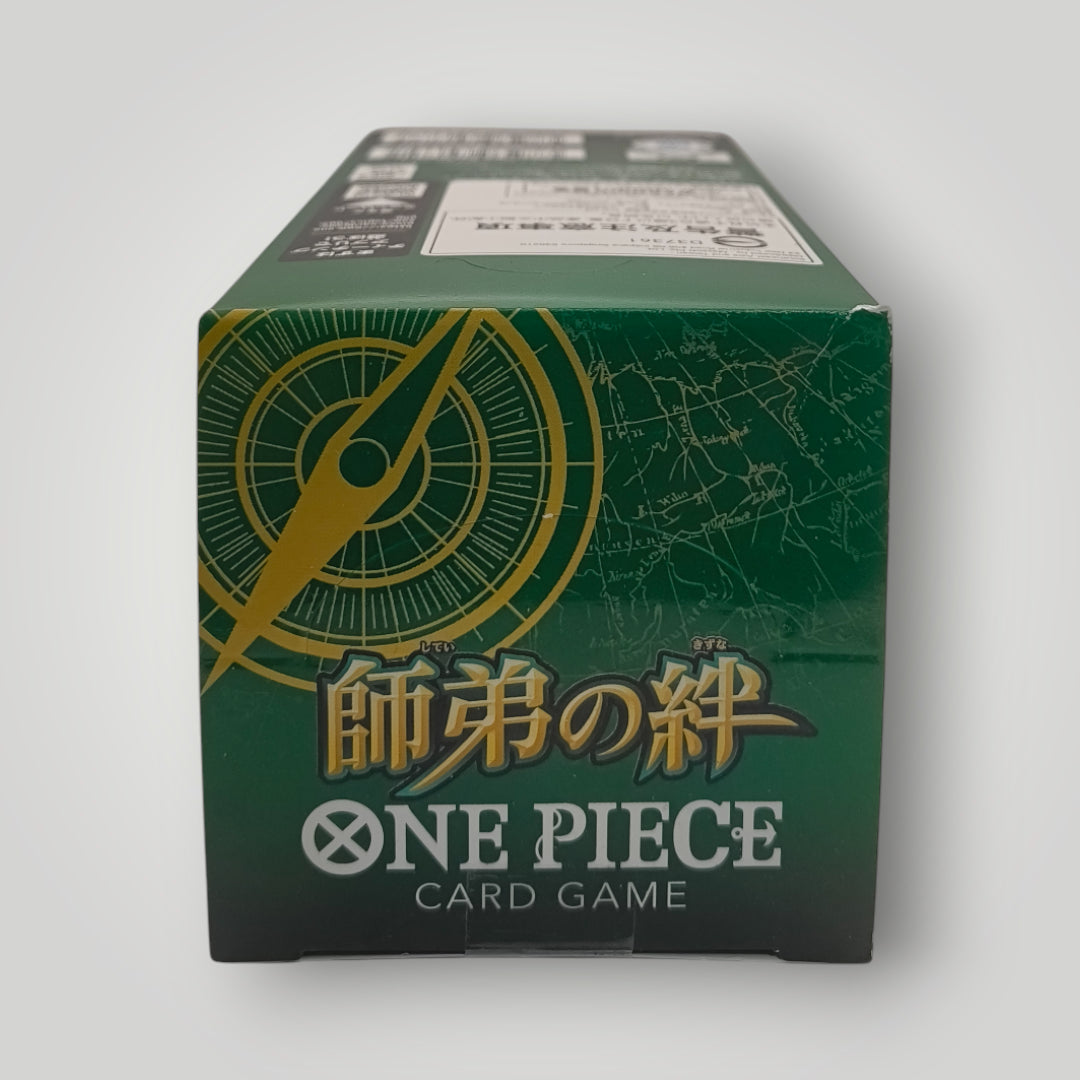 Green OP-12 Legacy of the Master One Piece Card Game booster box with gold compass design and Japanese text.
