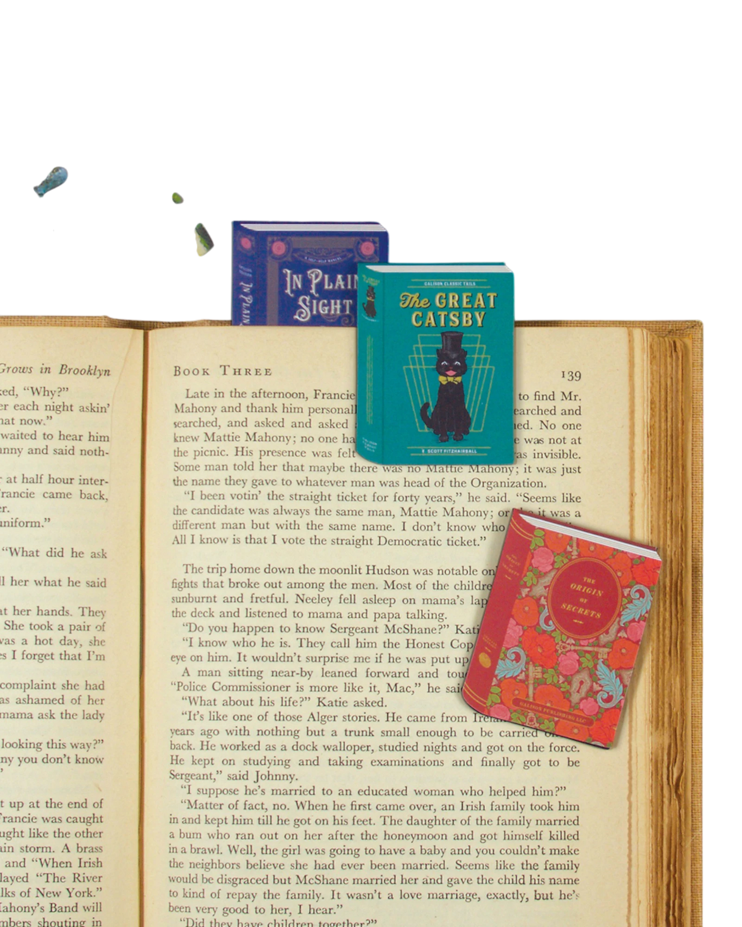 Ripperholics set of three vintage book-shaped magnetic bookmarks resting on an open antique book page